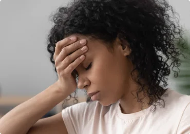 African woman sitting on couch feels unhappy having problems